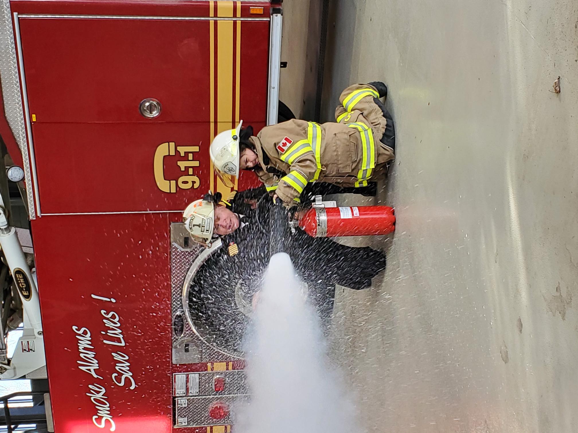 (2) Kathryn Holliday learns how to properly use a fire extinguisher under the close supervision of St. Marys Fire Chief Richard “Andy” Anderson