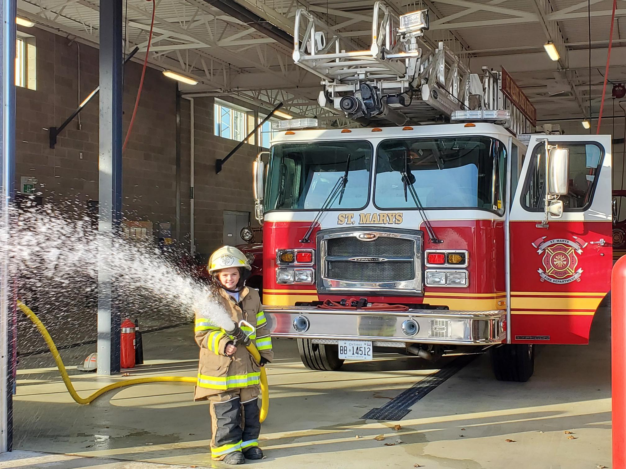 (3) Part of Kathryn Holiday’s “Fire Chief for a Day” experience included learning how to spray water from a fire hose and trying on bunker gear. 