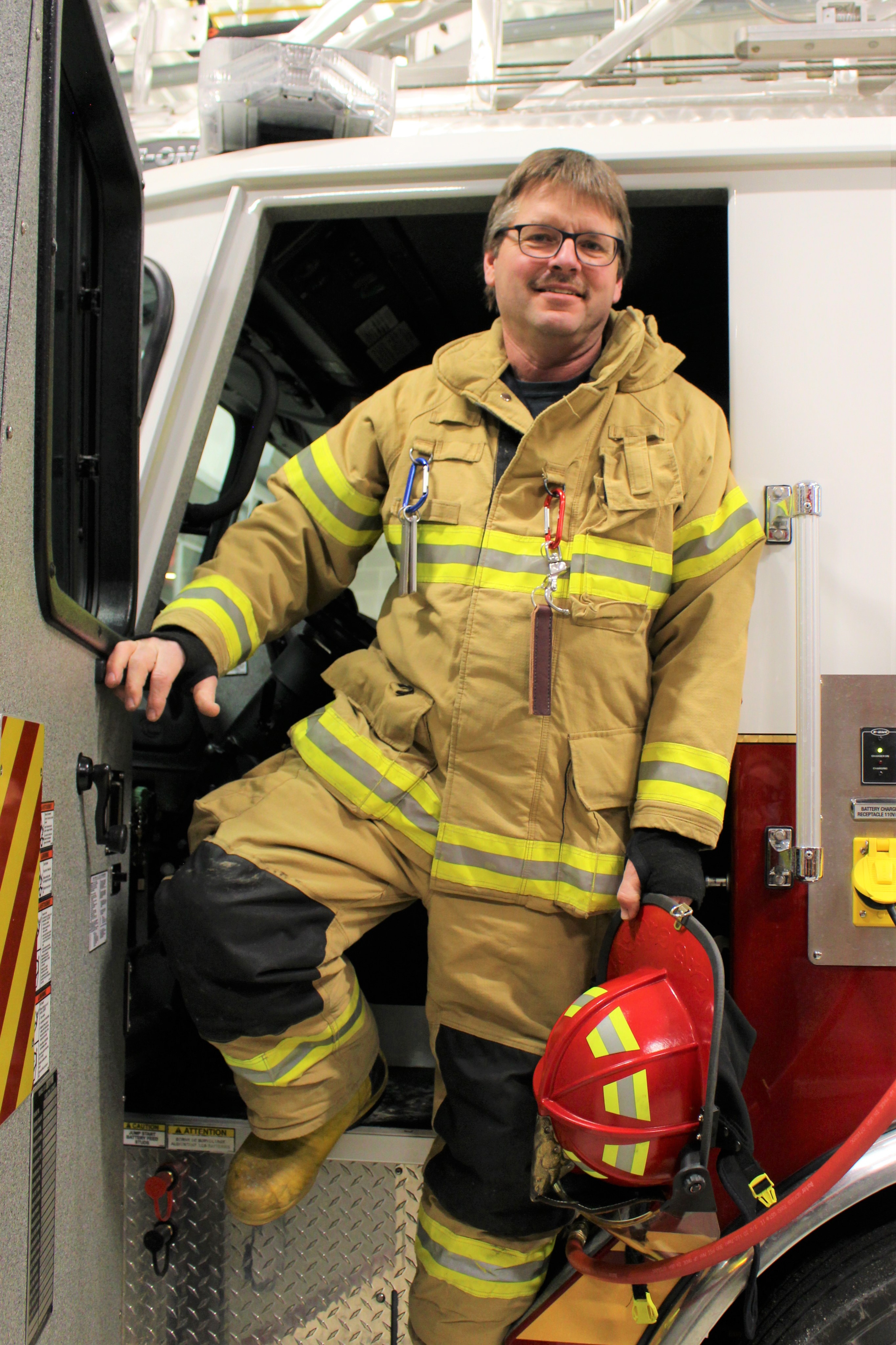 Captain Dale Robinson standing in door of a fire truck