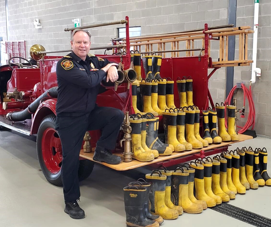 Fire Chief posing with donation of boots