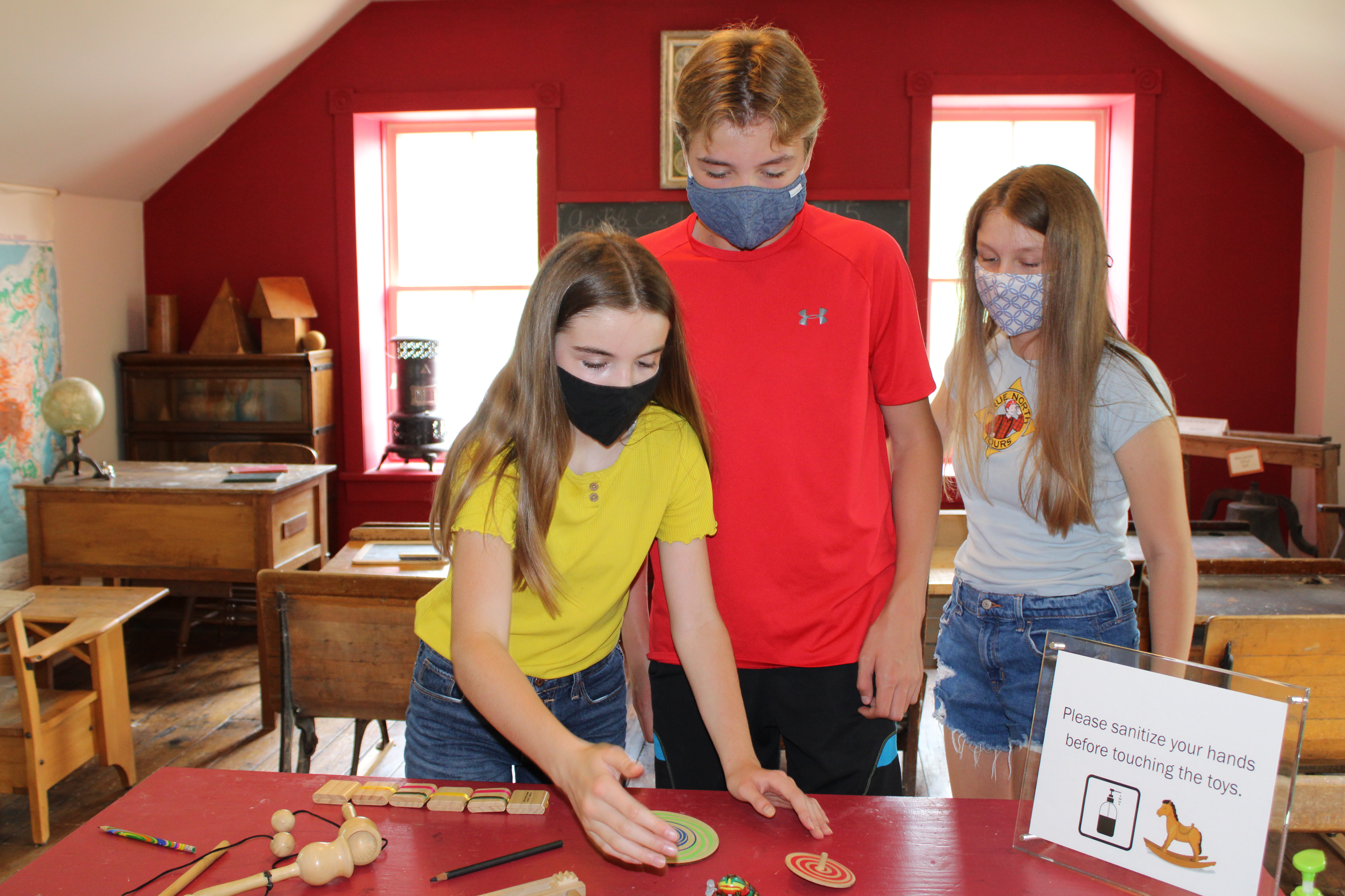 Three youth looking at antique toys