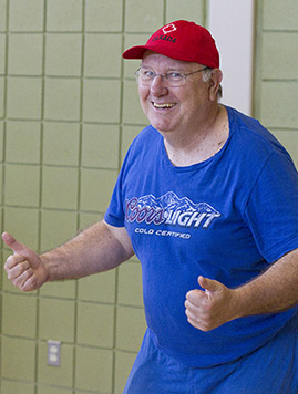 Older adult man smiling and showing thumbs-up sign