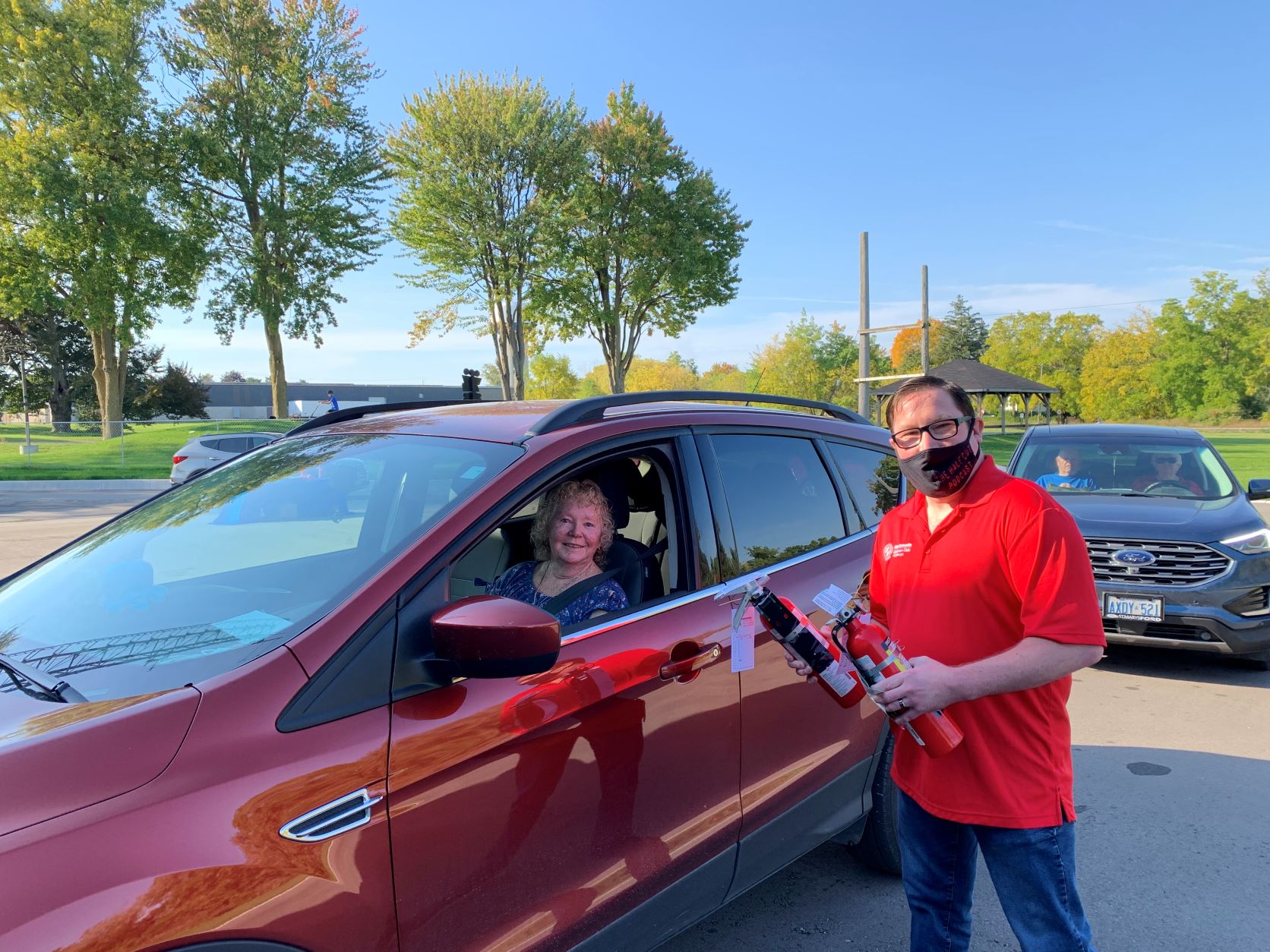 St. Marys Kinsmen Chris Swarthout hands a local resident a fire extinguisher for her vehicle at the first Cindy’s Law Fire Extinguisher Giveaway on October 2, 2021.