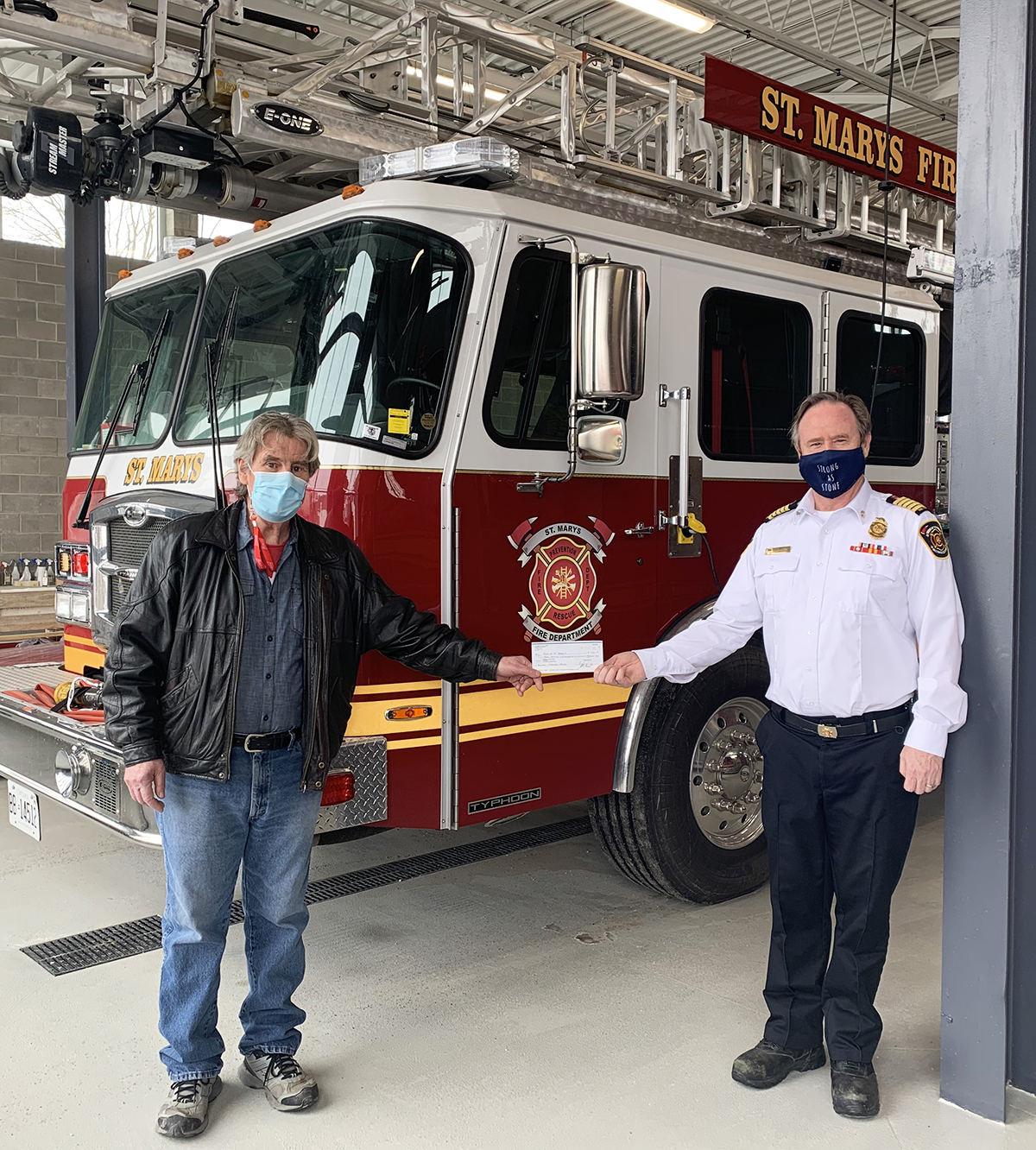 Lion President Charlie Albers presents a $7,500 donation to Fire Chief Richard “Andy” Anderson.