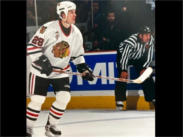 Mark Bell skating on the ice with a referee